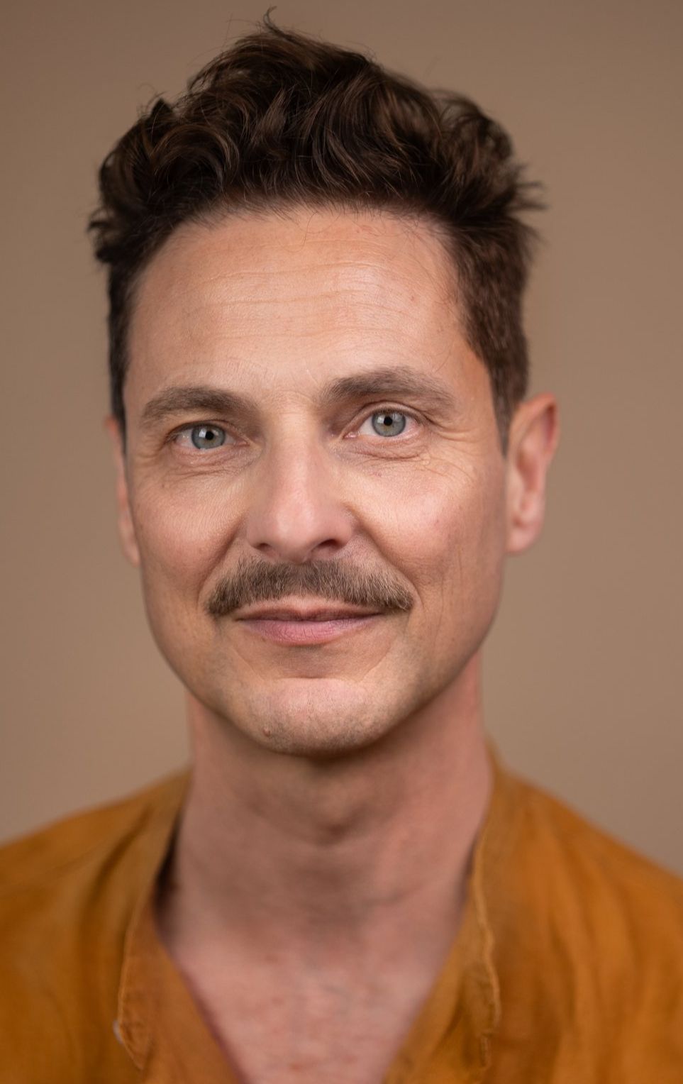 Close up of Italian, polyglot actor Antonio Pauletta, taken by Virginia Brown. Smiley, relaxed expression, conveying kindness, wit, wisdom, trust, reliability. 